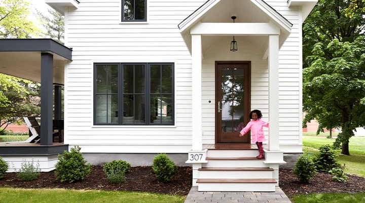 traditional wood and glass front door and black framed windows