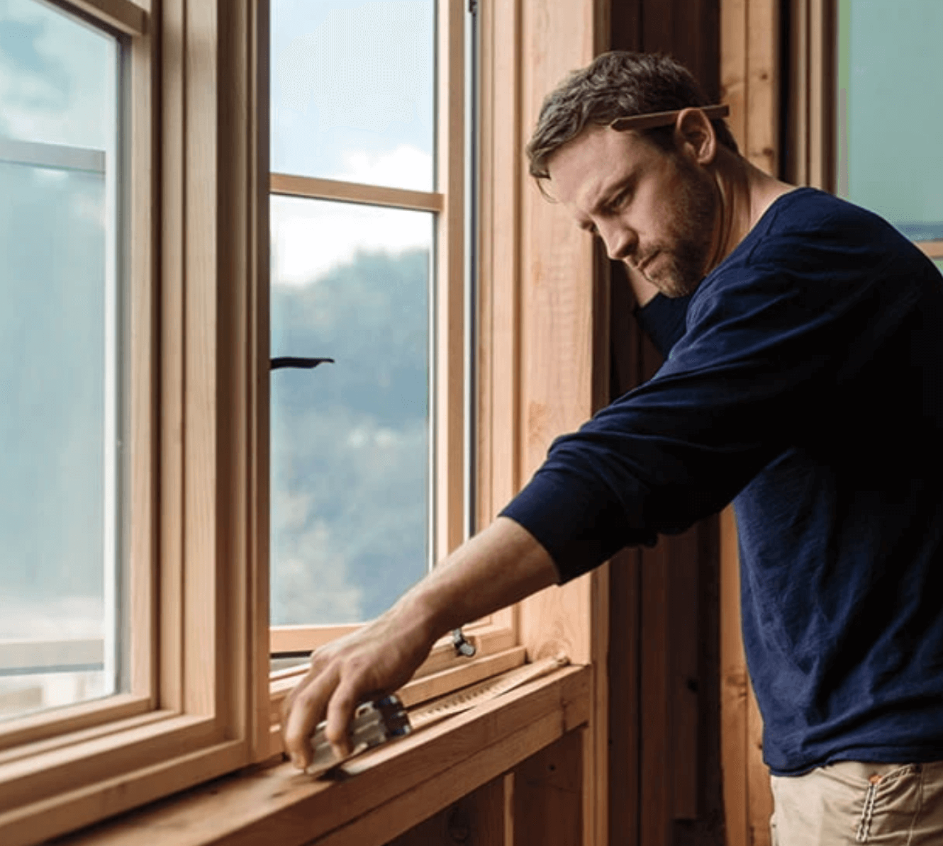 remodeler measuring a window sill