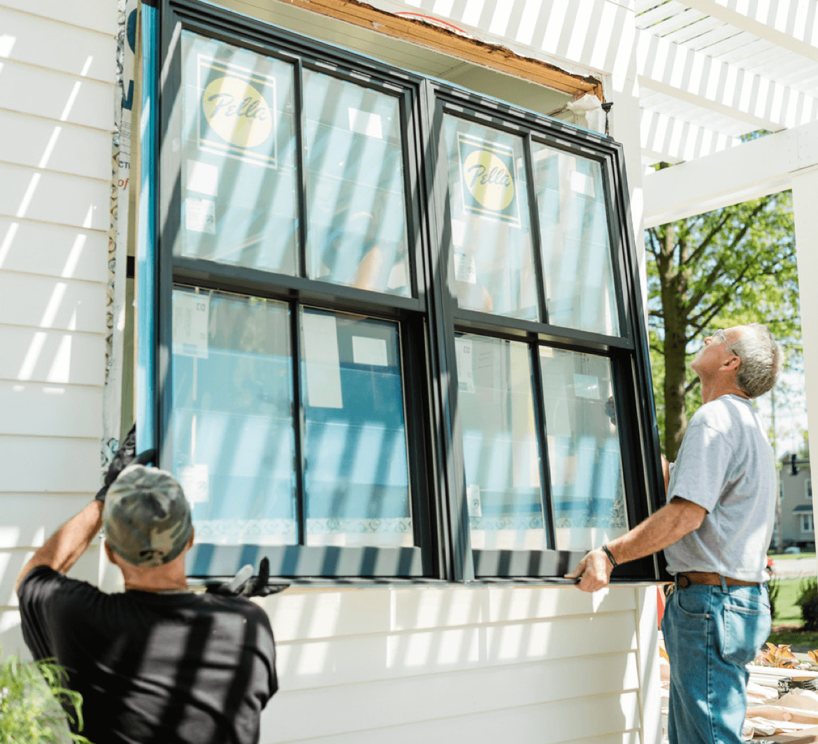 builder installing a black framed window
